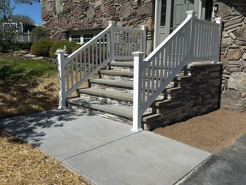 Stone veneer steps with white vinyl railings